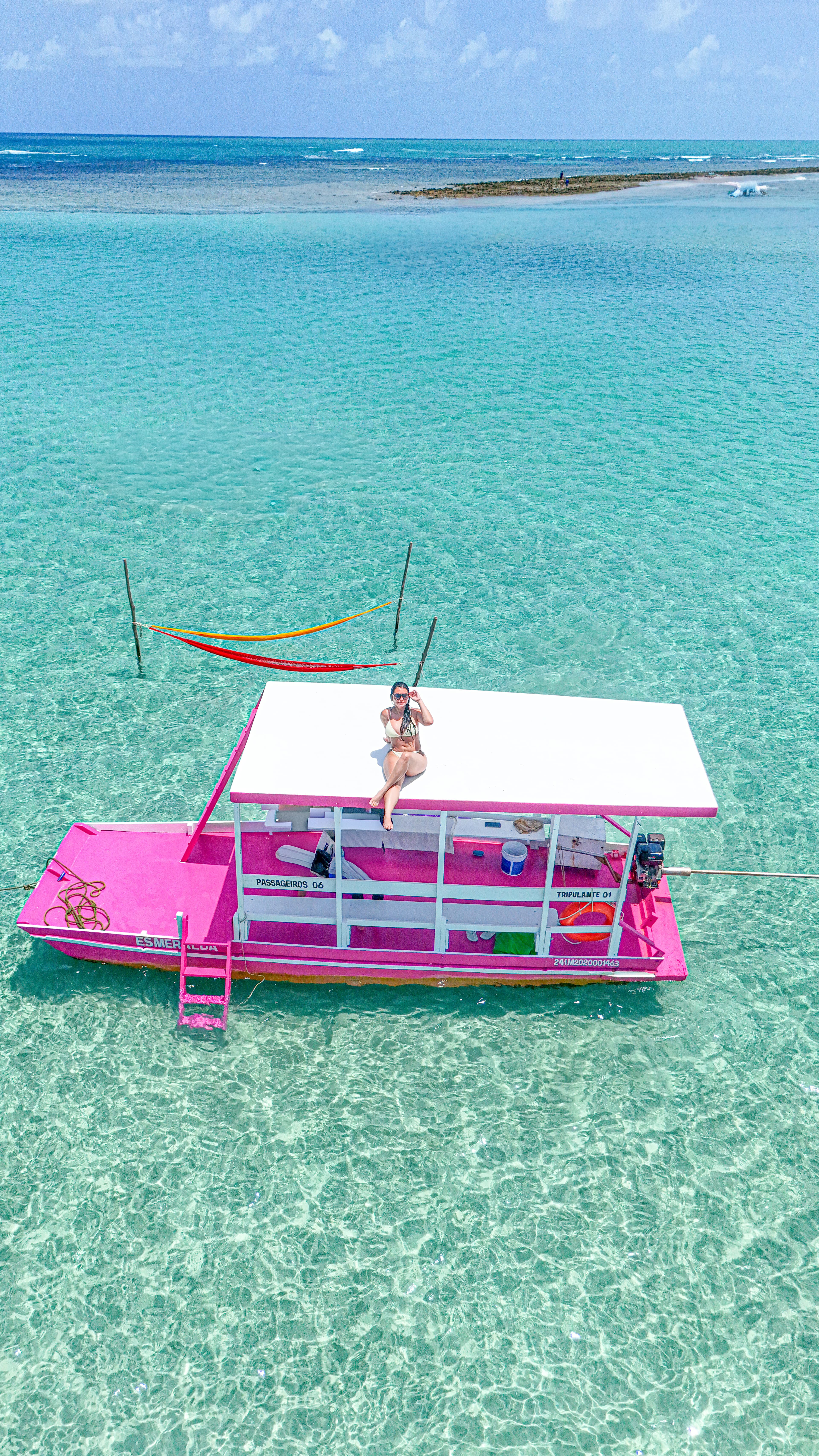 Woman relaxing on a colorful float in crystal clear turquoise water.